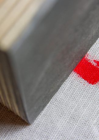 a piece of plywood on fabric with red color as example for a new abstract technology stock photo