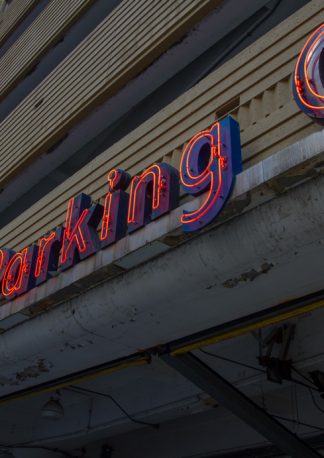 interesting perspective of a red parking neon sign